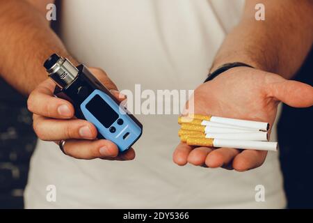 Männlich hält Zigaretten und Vape Inhalator aus nächster Nähe Stockfoto