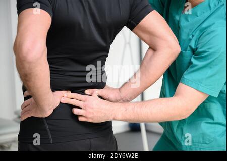 Rückansicht eines Physiotherapeuten, der den Mann auf den Rücken untersucht. Hochwertige Fotos Stockfoto