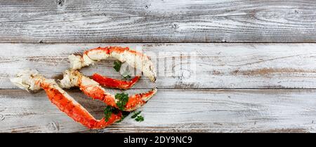 König Krabben Krallen und Beine auf weißem rustikalem Holz in Flaches Lay-Format Stockfoto