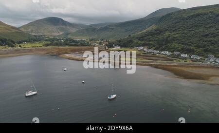 Yachten, Schiffe, Boote bei Scotland Ocean Aerial. Seeseite der Meeresbucht erstaunlich niemand Natur Landschaft im Sommer bewölkten Tag. Filmische Kreuzfahrt-Landschaft auf Arran Island, Großbritannien, Europa Stockfoto