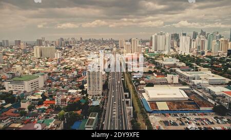 Top down Verkehrsautobahn mit Autos, LKW-Antenne. Städtischer Transport an der Brücke Straße in der Metropole Manila, Philippinen, Asien. Filmische Stadtlandschaft der Innenstadt Autobahn Drohne aufgenommen Stockfoto