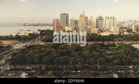 Entworfen Park Landschaft Antenne. Moderne Wolkenkratzer über grünen tropischen Pflanzen und Bäumen. Breites Grastal mit Blumen. Erstaunliche Stadtbild Natur von Manila Stadt, Philippinen, Asien Stockfoto