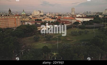 Moderne Gebäude, Wolkenkratzer an der Verkehrsstraße mit Autoantenne. Ferienhäuser und Häuser der Innenstadt von Manila Stadt, Philippinen, Asien. Filmische Stadtlandschaft der tropischen Metropole Stockfoto