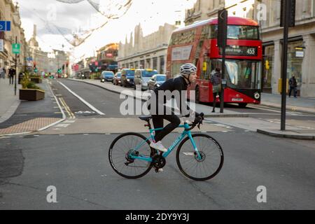 London, Großbritannien. Dezember 2020. Ein Radfahrer auf einer halb verlassenen Regent Street während Heiligabend 2020. Kredit: SOPA Images Limited/Alamy Live Nachrichten Stockfoto