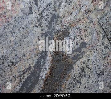 Nahaufnahme eines flachen grauen Steins mit einer abgebrochenem Untergrund und Spuren von Rohbearbeitung. Hintergrund, Textur. Stockfoto