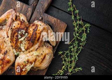 Gegrilltes Hähnchen mit Chimichurri-Sauce, auf schwarzem Holzhintergrund, Draufsicht Stockfoto