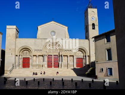 Außerhalb der Abbatiale Saint-Gilles du Gard in Saint-Gilles, mit dem Stadtplatz, wo sich die Menschen auf Stufen treffen Stockfoto