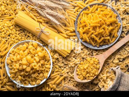 Spaghetti und verschiedene Arten von Pasta auf einem Teller und auf dem Tisch. Stockfoto