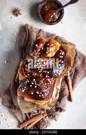 Babka oder Brioche Brot mit Aprikosenmarmelade und Nüssen. Hausgemachtes Gebäck zum Frühstück. Konkreter Hintergrund. Draufsicht. Stockfoto