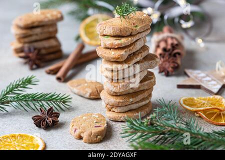 Gestapelte würzige Butterkekse mit kandierten Früchten, Zimtstangen und Anis. Festliche Weihnachten oder Neujahr Hintergrund mit Tannenzweigen und getrockneten oran Stockfoto