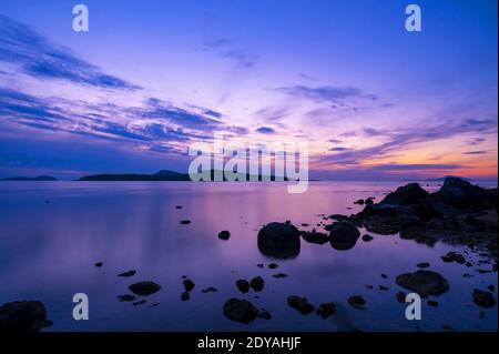 Wunderschöne Sonnenaufgang oder Sonnenuntergang Seeslandschaft über andaman Meer in Phuket Thailand Epische Morgendämmerung Meereslandschaft mit Felsen in der Langzeitbelichtung Vordergrund im Stockfoto