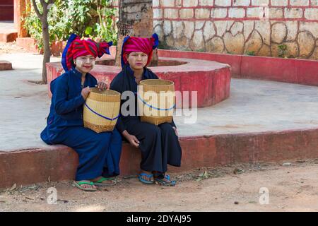 Junge Pa O Damen sitzen Körbe mit Thanaka auf Gesicht in Shwe Indein Pagode Komplex, Shan Staat, Inle See, Myanmar (Burma), Asien im Februar Stockfoto