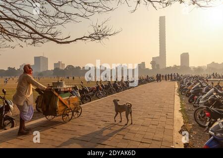 Verkäufer mit Hand gezogen Warenkorb Verkauf Zitronenwasser für den Morgen Spaziergänger auf Kolkata Maidan Bereich mit Blick auf die Stadtlandschaft bei sonnenaufgang Stockfoto