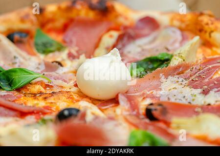 Frisch gebackene Pizza mit Tomatensauce, Prosciutto und Mozzarella. Italienische Küche. Selektiver Fokus Stockfoto