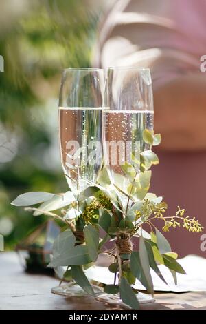 Champagner in Gläsern mit grünen Blättern. Champagnergläser Hintergrund mit dem Platz für Ihren Text Stockfoto