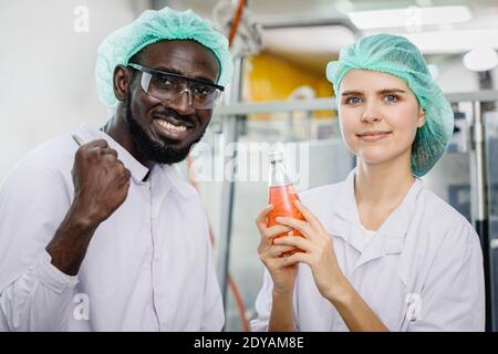 Portrait des Mischrenners in der Lebensmittel- und Getränkefabrik Glücklicher Arbeiter zusammen schauen Kamera und lächeln Stockfoto