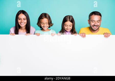 Foto Porträt der großen Familie mit kleinen Kindern halten groß Weißes Papier Blatt mit Copyspace isoliert auf lebendige blaugrün gefärbt Hintergrund Stockfoto