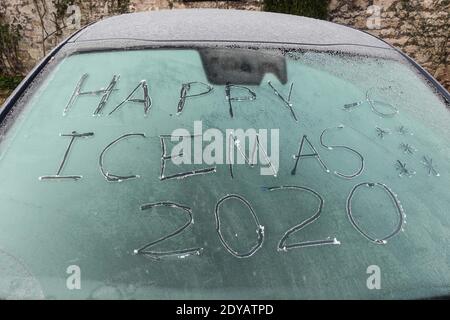 Garstang, Lancashire, 25. Dezember 2020. Eine Windschutzscheibe, auf der die Worte „Happy Icemas -6 Grad“ in Eis eingeätzt wurden, als am Weihnachtstag im Jahr 2020 Temperaturen unter Null in Nordengland herrschten. Temperaturen von minus 6 fror Garstang in Lancashire bis zum Kern ein. Eine frostige Decke mit Autos und Windschutzscheiben. Quelle: Stop Press Media/Alamy Live News Stockfoto