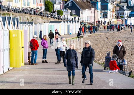 Lyme Regis, Dorset, Großbritannien. Dezember 2020. UK Wetter: Einheimische und Familien genießen einen Morgenspaziergang am Strand entlang an einem hellen, knackigen und sonnigen Weihnachtstag bei Lyme Reegis. Kredit: Celia McMahon/Alamy Live Nachrichten Stockfoto