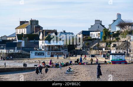 Lyme Regis, Dorset, Großbritannien. Dezember 2020. UK Wetter: Einheimische und Familien genießen einen Morgenspaziergang am Strand entlang an einem hellen, knackigen und sonnigen Weihnachtstag bei Lyme Reegis. Kredit: Celia McMahon/Alamy Live Nachrichten Stockfoto