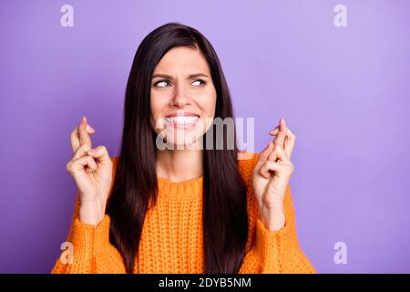 Foto Porträt Frau trägt Strickpullover Blick auf leeren Raum Gekreuzte Finger nervös isoliert lebendige lila Farbe Hintergrund Stockfoto