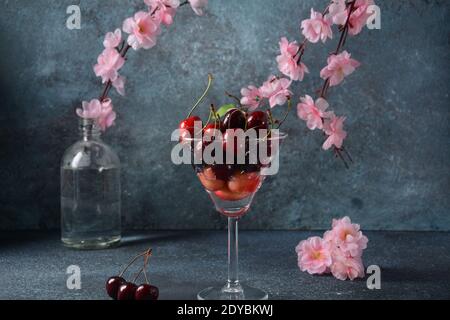 Süße rote Kirschen in einem Glas. Cherry close-up in einem Glas mit Wassertropfen. Süßes Dessert im Sommer Stockfoto