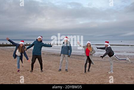 Portobello, Edinburgh, Schottland, Großbritannien. 25 Dezember 2020. Bewölkt mit 3 Grad Temperatur für diese Slowaken tragen Weihnachtsmützen, die in einer sozialen Blase in der Stadt leben und feiern Weihnachten am Meer, da sie nicht nach Hause reisen konnten aufgrund der Covid-19 Reisebeschränkungen. Quelle: Arch White/ Alamy Live News. Stockfoto