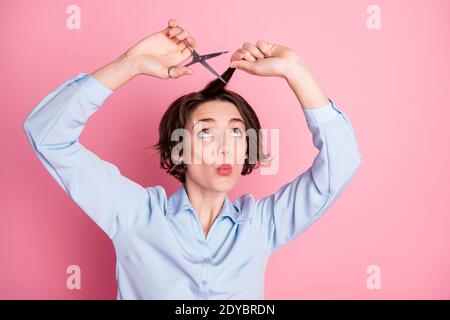 Foto von attraktiven lustige hübsche Dame halten Frisur Locken schneiden Split beschädigte Enden professionelle Schere aufgeregt ändern Stil Look up Tragen Sie ein blaues Hemd Stockfoto