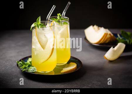 Melonensaft, Limonade in Gläsern mit Eis und Melonenscheiben garniert mit Basilikumblättern. Konzept des frischen Sommergetränks Stockfoto