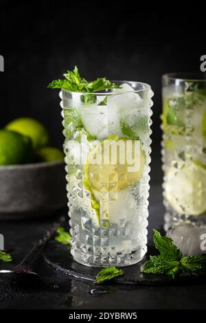 Glas Eislimonade mit Limette und Minze, kaltes Sommergetränk auf dunklem Hintergrund Stockfoto