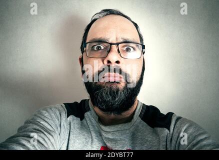 Lustiger Mann mit dem Bart, der Ausdrücke macht Stockfoto