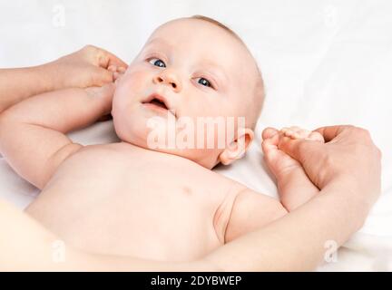 Fünf Monate Baby erhalten Massage-Therapie in der Kinderklinik. Der manuelle Therapeut manipuliert die Arme von Kindern Stockfoto