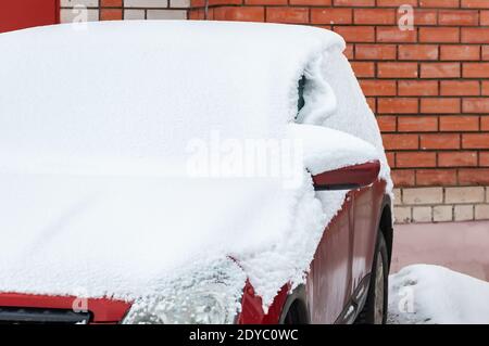 Nahaufnahme eines schneebedeckten Autos auf einem Parkplatz in Ein Wohngebiet der Stadt Stockfoto