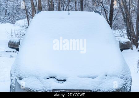 Nahaufnahme eines schneebedeckten Autos auf einem Parkplatz in Ein Wohngebiet der Stadt Stockfoto