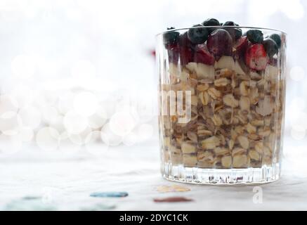 Frühstück, Essen, gesunde Ernährung und Diät-Konzept - schließen Sie ein Glas Müsli Haferflocken mit Chia, Cranberry und amerikanische Heidelbeeren auf dem Tisch Stockfoto