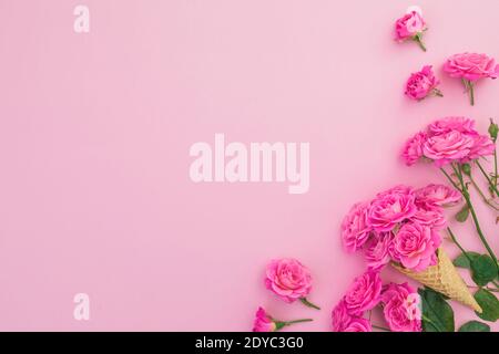 Blumenrahmen von Rosen Blumen isoliert auf rosa Hintergrund. Flach liegend, Draufsicht. Valentinstag Stockfoto