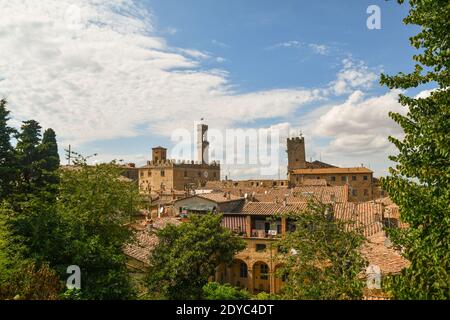 Blick auf die Dächer der etruskischen Stadt Volterra mit dem Palazzo dei Priori gegen klaren blauen Himmel im Sommer, Pisa, Toskana, Italien Stockfoto