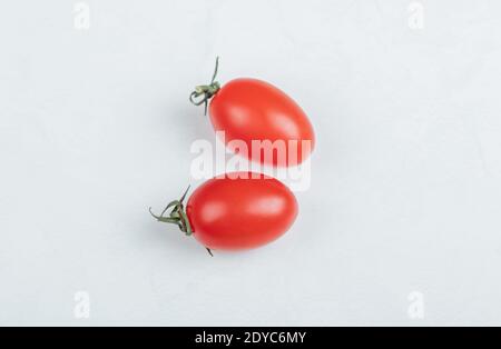 Nahaufnahme von zwei Kirschtomaten. Auf weißem Hintergrund Stockfoto