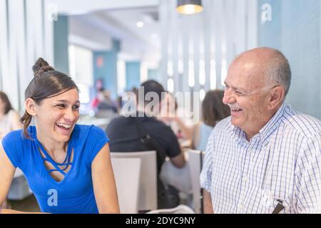 Reifer Mann und junge Frau genießen und lächeln, verbringen Zeit zusammen. Stockfoto