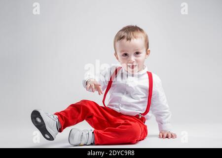 Hübscher kleiner Junge, in Rot auf weißem Hintergrund gekleidet. Junge und Kindheit Konzept. Stockfoto