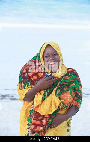Porträt einer Frau, die Kanga am Strand trägt Stockfoto