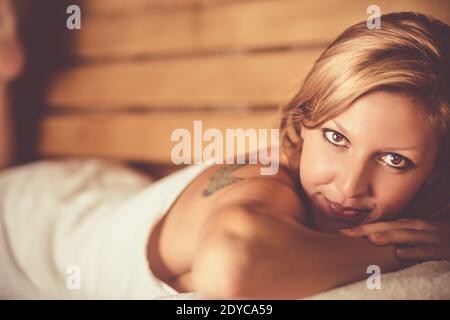 Dame, die sich in der traditionellen finnischen Holzsauna entspannt. Stockfoto