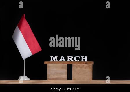 Hölzerner Märzkalender mit polnischer Flagge auf schwarzem Hintergrund. Feiertage in Polen im März Stockfoto
