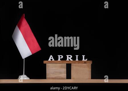 Holzkalender April mit polnischer Flagge auf schwarzem Hintergrund. Feiertage in Polen im April Stockfoto