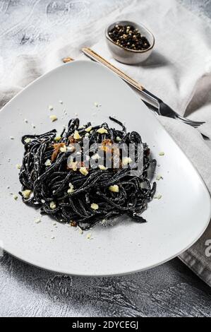 Schwarze Spaghetti mit Thunfisch in Sahne-Sauce. Grauer Hintergrund. Draufsicht Stockfoto