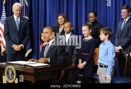 US-Präsident Barack Obama unterzeichnet eine Reihe von Exekutivbefehlen über die neuen Waffenrechtsvorschläge der Regierung als (L-R) Vizepräsident Joe Biden und Kinder, die Briefe an das Weiße Haus über Waffengewalt schrieben, Hinna Zeejah, Taejah Goode, Julia Stokes und Grant Fritz, Schauen Sie im Eisenhower Executive Office Gebäude 16. Januar 2013 in Washington, DC, USA. Foto von Olivier Douliery/ABACAPRESS.COM Stockfoto