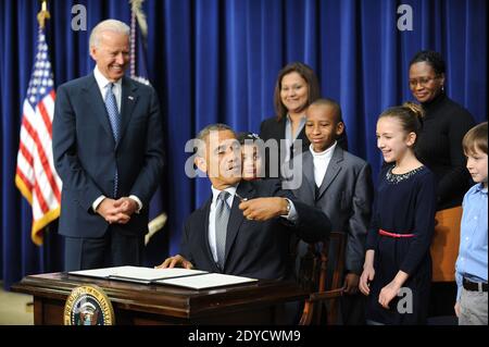 US-Präsident Barack Obama unterzeichnet eine Reihe von Exekutivbefehlen über die neuen Waffenrechtsvorschläge der Regierung als (L-R) Vizepräsident Joe Biden und Kinder, die Briefe an das Weiße Haus über Waffengewalt schrieben, Hinna Zeejah, Taejah Goode, Julia Stokes und Grant Fritz, Schauen Sie im Eisenhower Executive Office Gebäude 16. Januar 2013 in Washington, DC, USA. Foto von Olivier Douliery/ABACAPRESS.COM Stockfoto