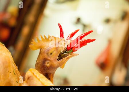Vietnam Hanoi Rote scharfe Chilischoten, die in einem Imbissstand in den Mund eines Hühners gestopft sind. Stockfoto