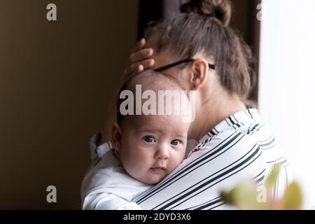 Kindheit, Mutterschaft, Krankheit Familienkonzepte - aufgeregt, müde nervös Geschäftsfrau Lady Mutter mit Kopfschmerzen Holding Säugling Kind neugeborenes Baby in Stockfoto
