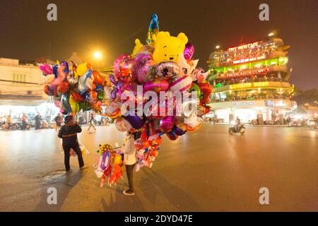 Vietnam Hanoi Ballon-Händler auf einer belebten Straße in der Nacht Stockfoto